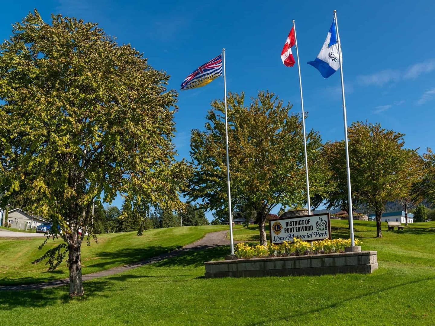 In Port Edward, a sign with flags flying proudly signals the presence of cozy cabins nestled in a grassy area recently rezoned.