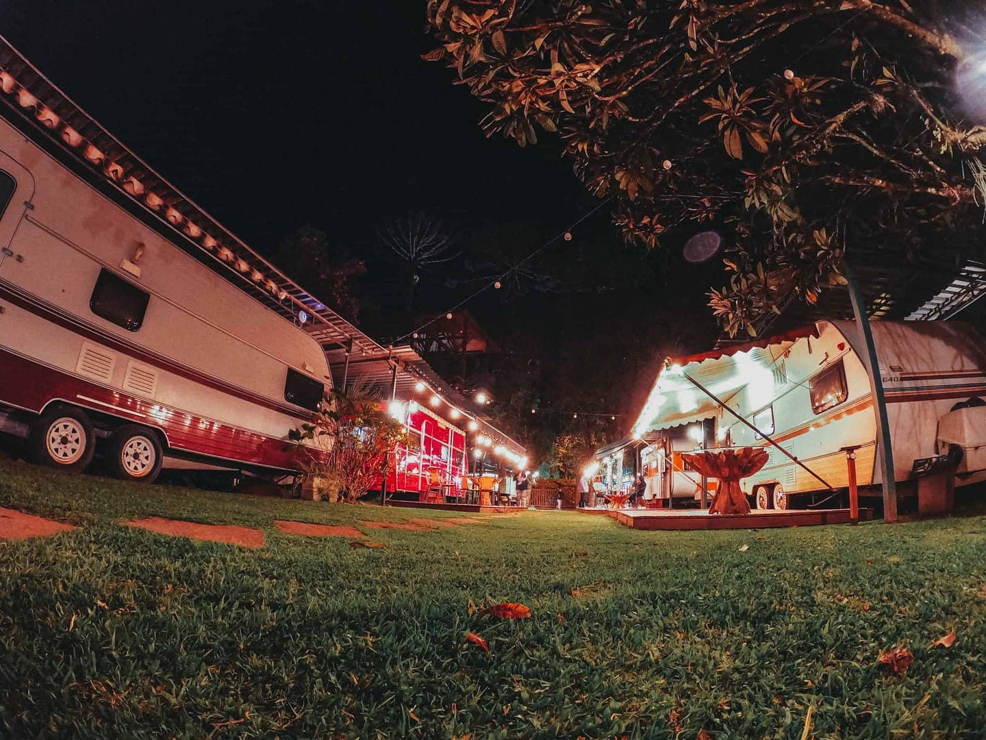 A group of CampersCard parked on the grass at night.