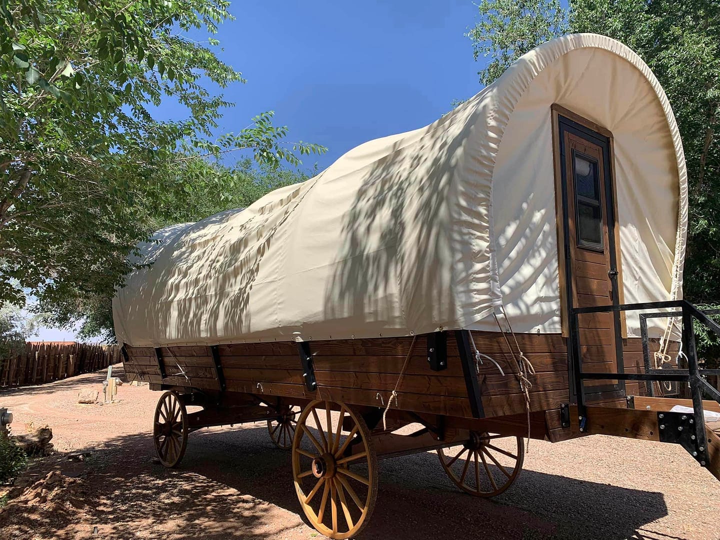 An interactive campground virtual tour showcases a covered wagon parked in front of a tree at Coral Sands RV Park.