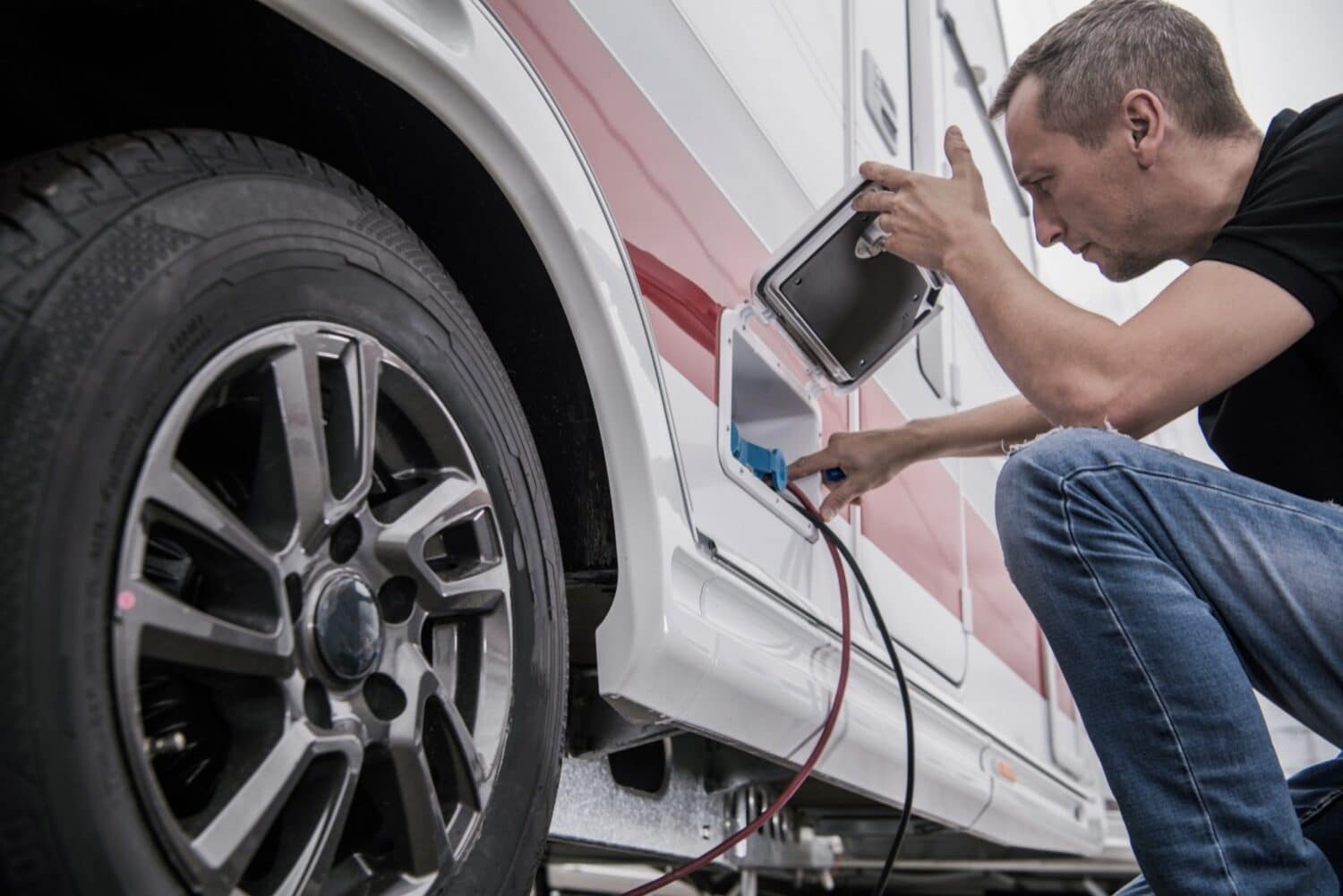 A man, recruited by RV Technical Institute during their Recruitment Drive, expertly plugs a battery into an RV.
