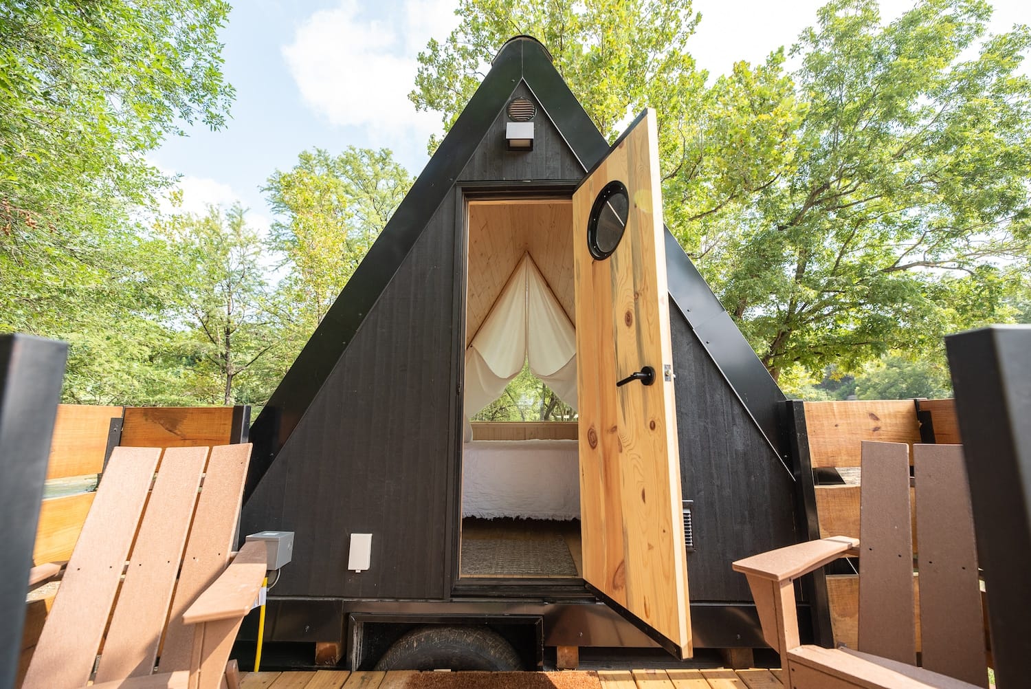 A tiny house with a door that opens up to a deck in the top luxury RV resort in Texas Hill Country.