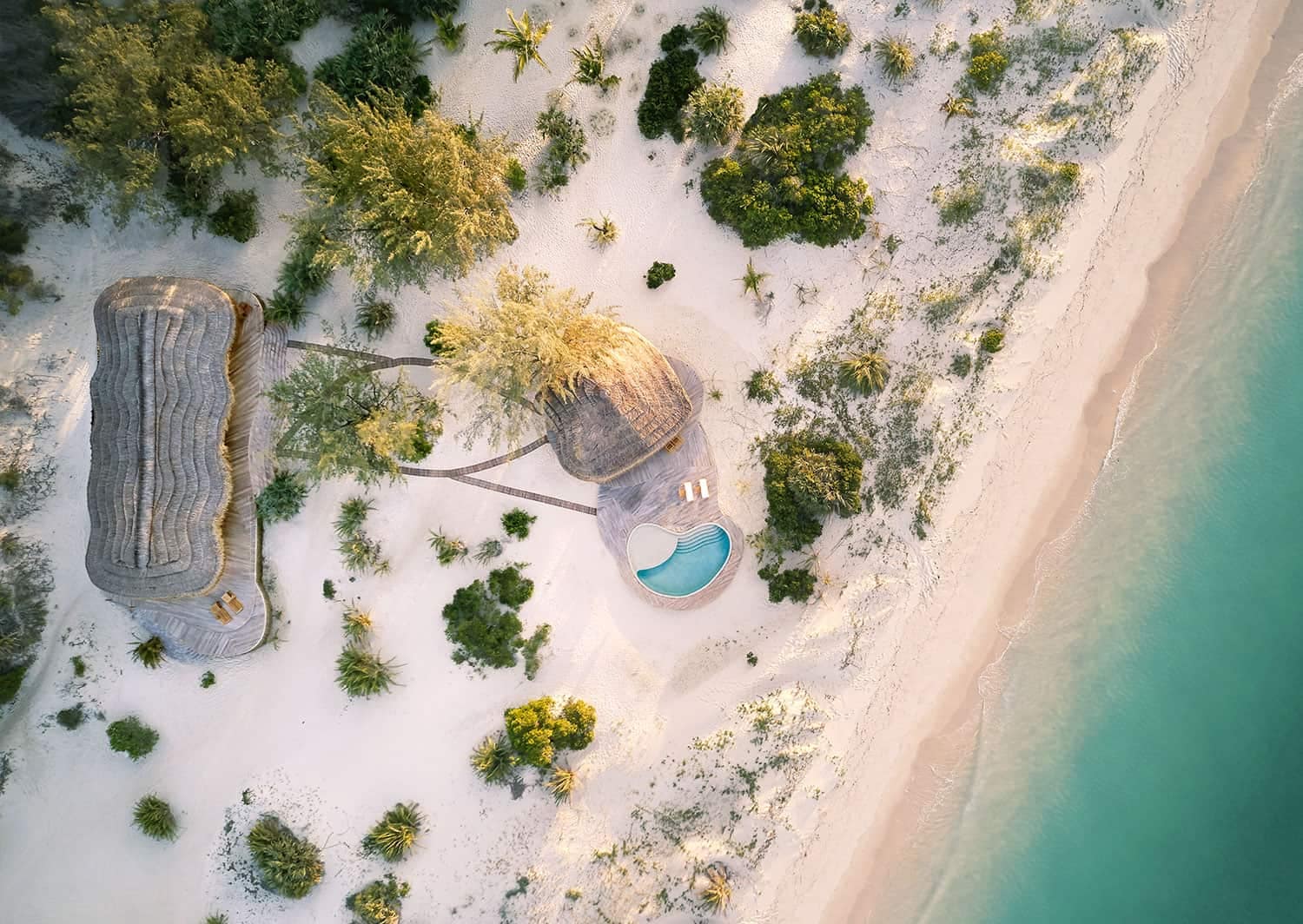 An aerial view of a beach with poolside huts in Kisawa Sanctuary, Mozambique.