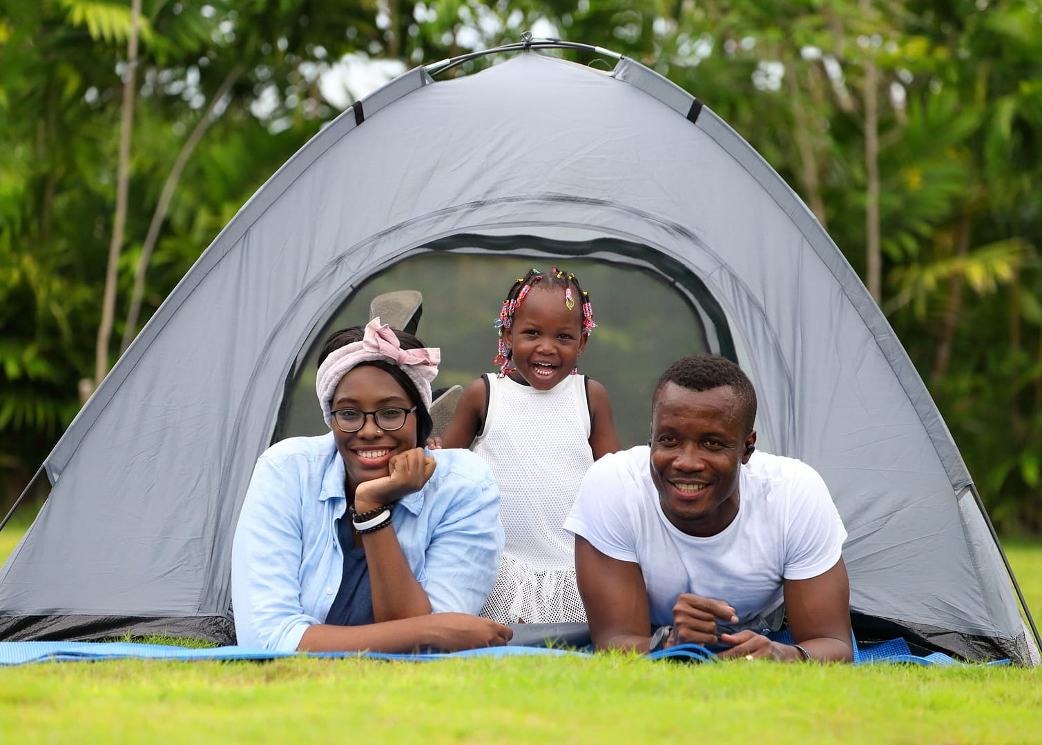 A family is posing in front of a tent at an iconic Parks Canada program event.