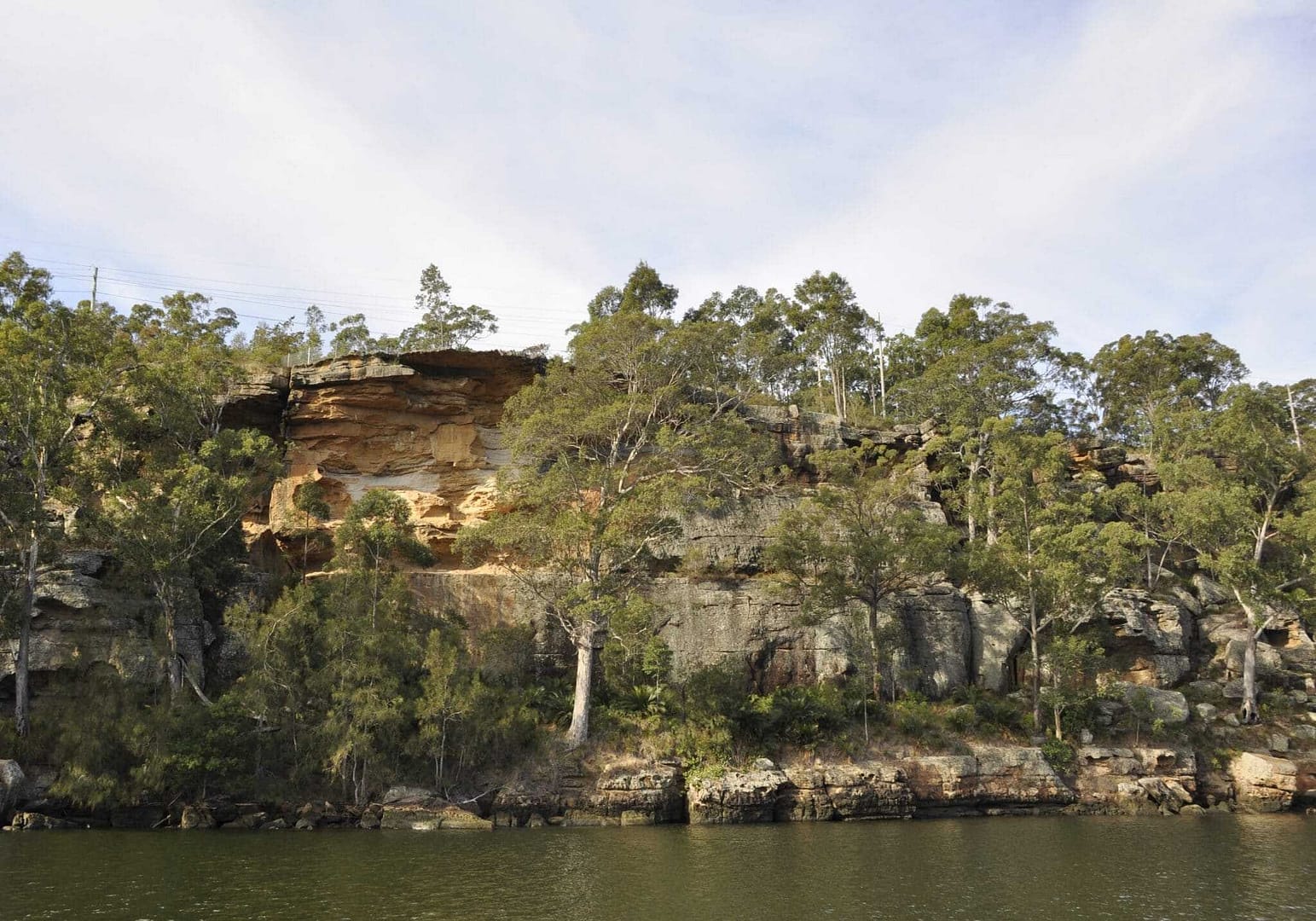 The Nowra Gateway Site, a former rock formation on the side of a body of water, has been transformed into a serene Short Stay Caravan Park.