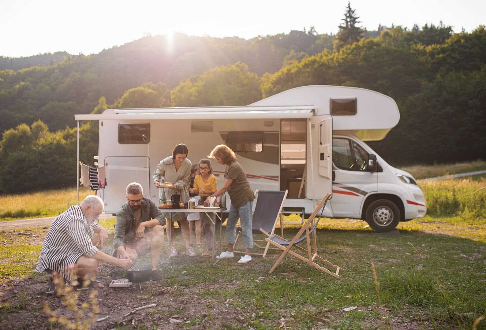 A group of people enjoying an Easter getaway around a campfire in front of an RV.