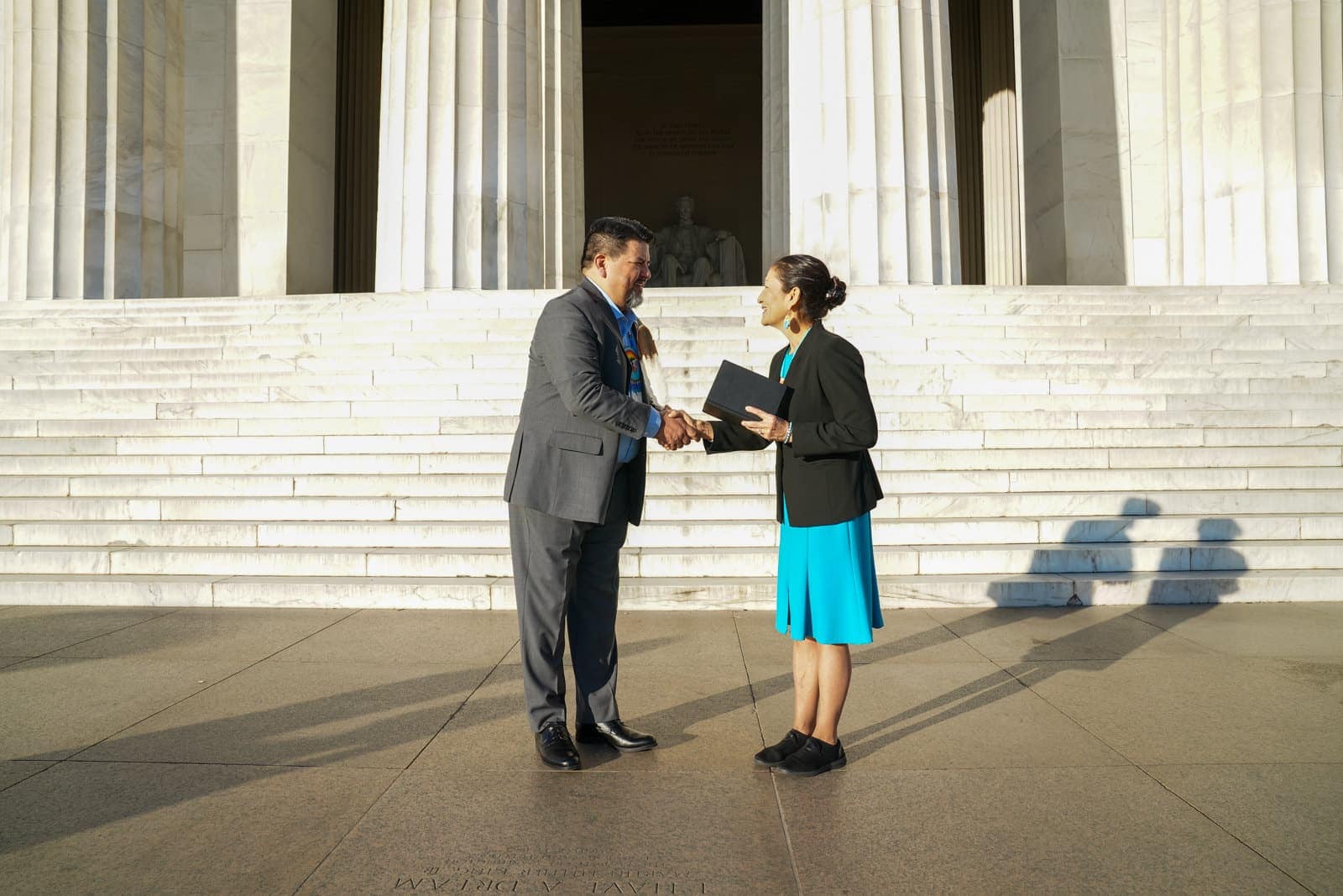 Charles F. Sams III, National Park Service Director, shaking hands in front of the Lincoln Memorial.