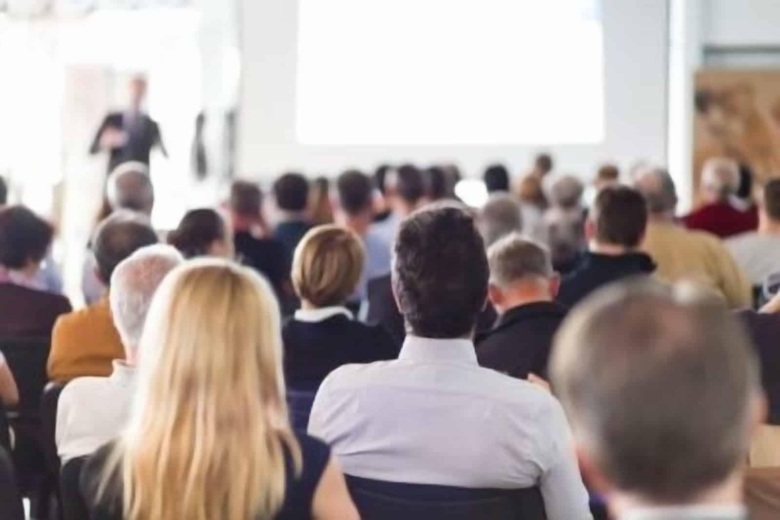 A group of people sitting in a conference room attending a RV Dealers Convention.