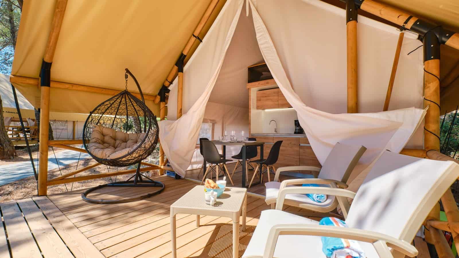 A Čikat tepee tent for glamping with chairs and a table.