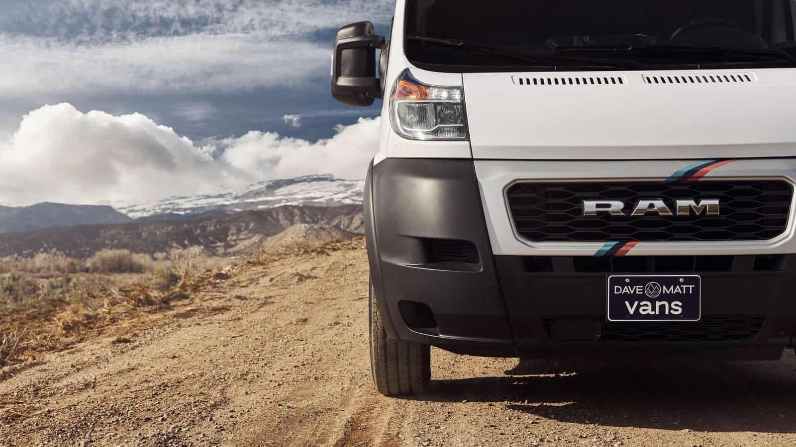 Introducing the front end of a new white ram truck driving down a dirt road, showcasing the 2022 Lifestyle Vehicles by Dave & Matt Vans.