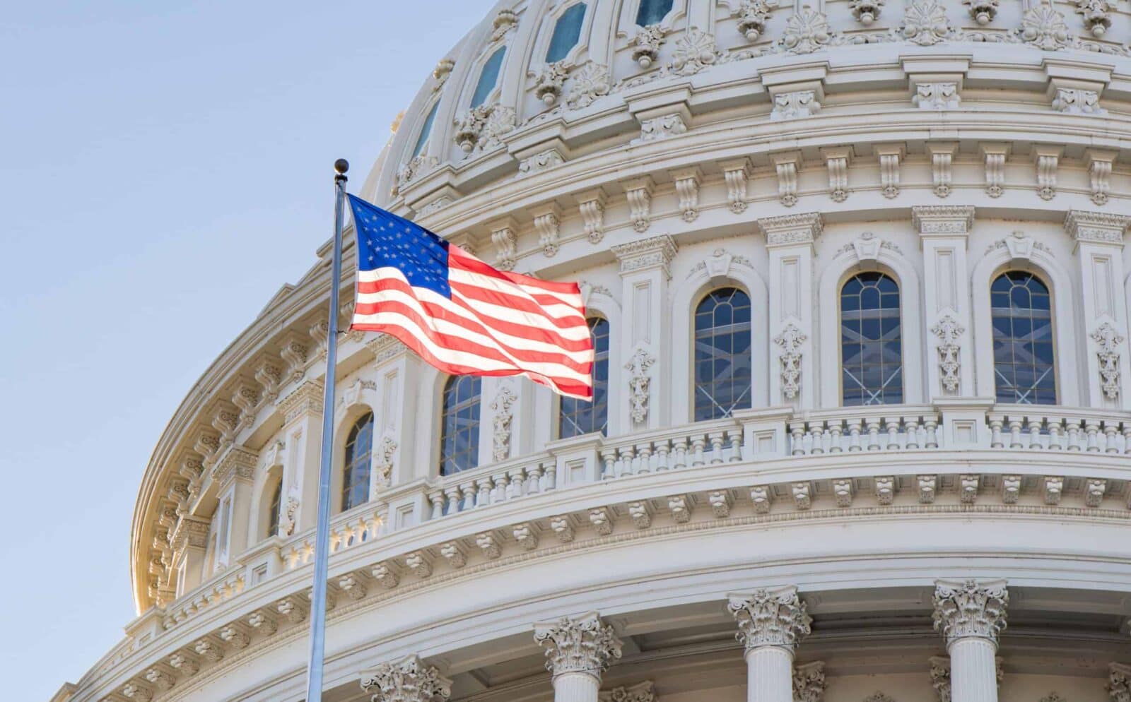 An American flag proudly flies in front of the U.S. Capitol building.