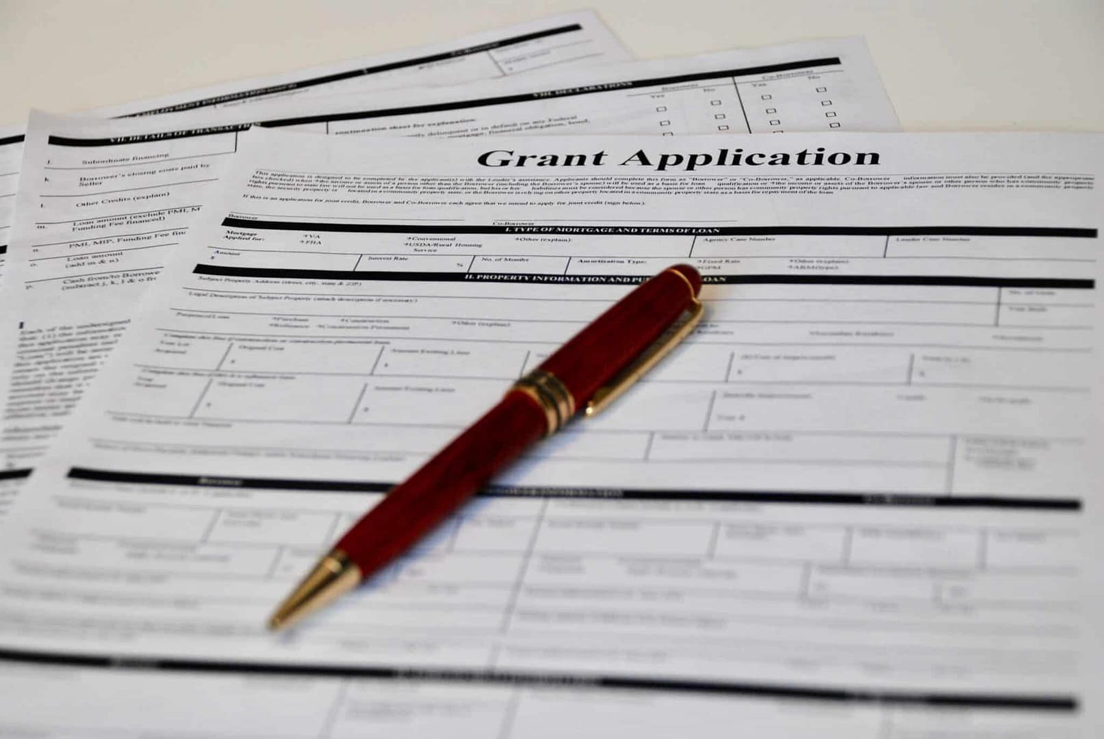 Grant application forms with a pen on top meant to improve the Cheboygan County Fairgrounds.