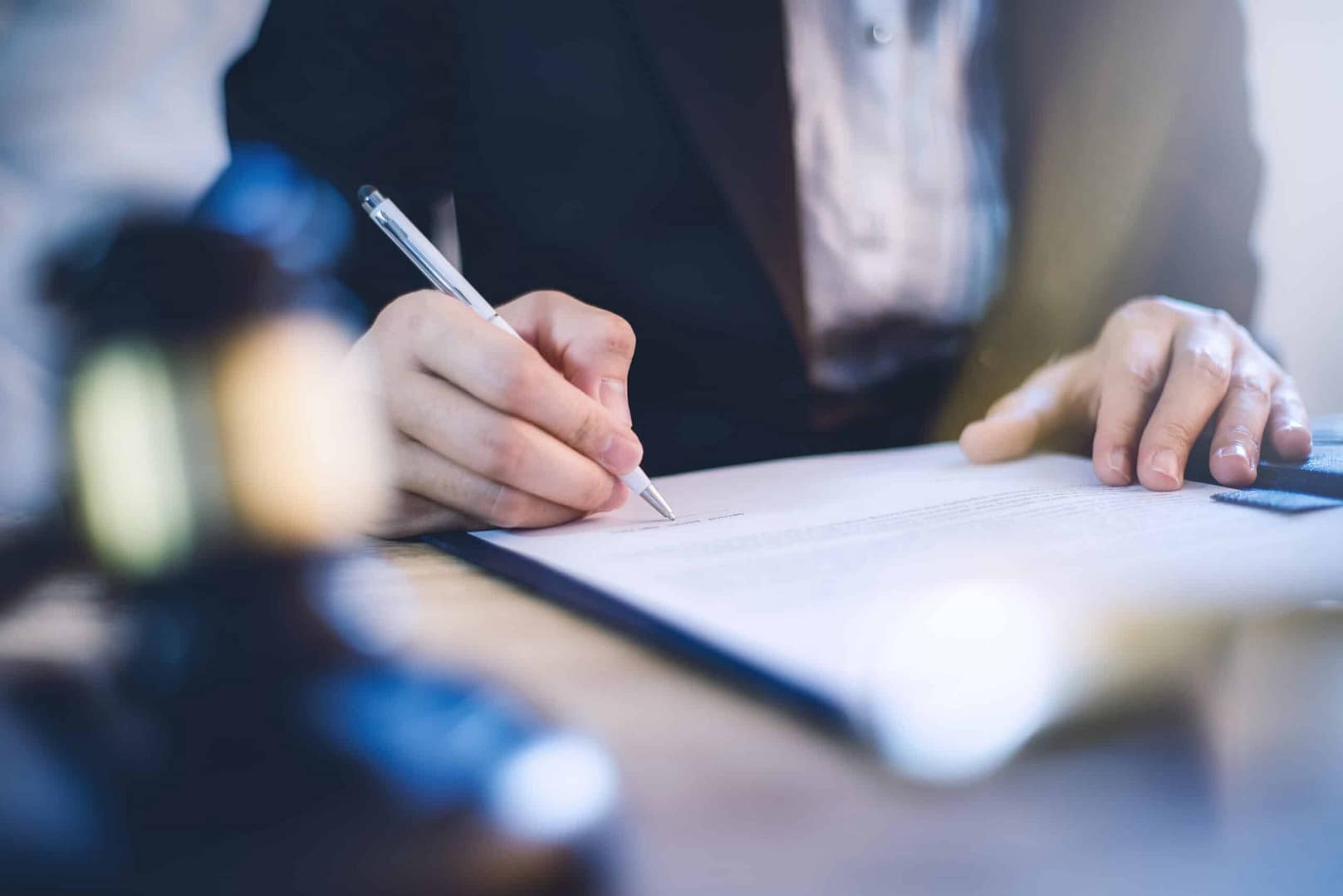 A woman signing a document related to Water Law with a gavel.