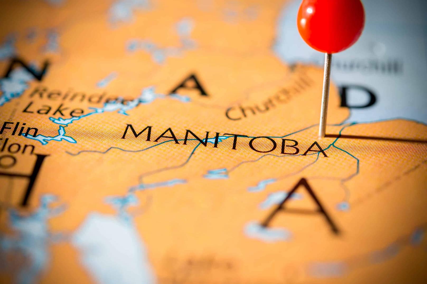 A red pin is pinned on a map of Manitoba, indicating a camping reservation system in place for the province.