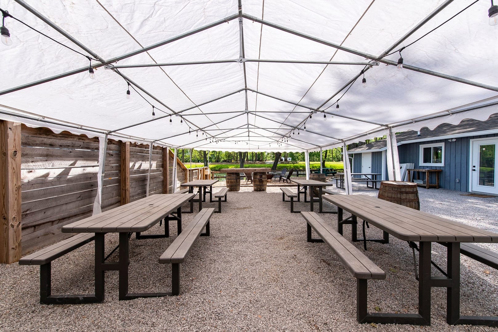 A white tent with tables and benches at Progress Park in Louisville for an event-centric expansion.