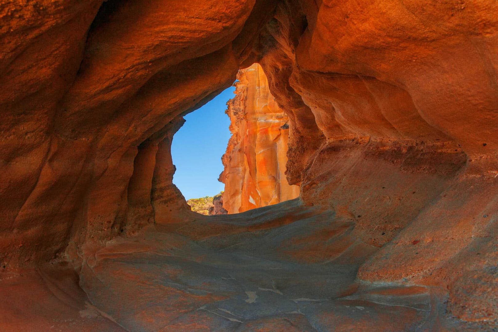 The inside of a canyon within Ben Boyd National Park, surrounded by locals and under a clear blue sky.