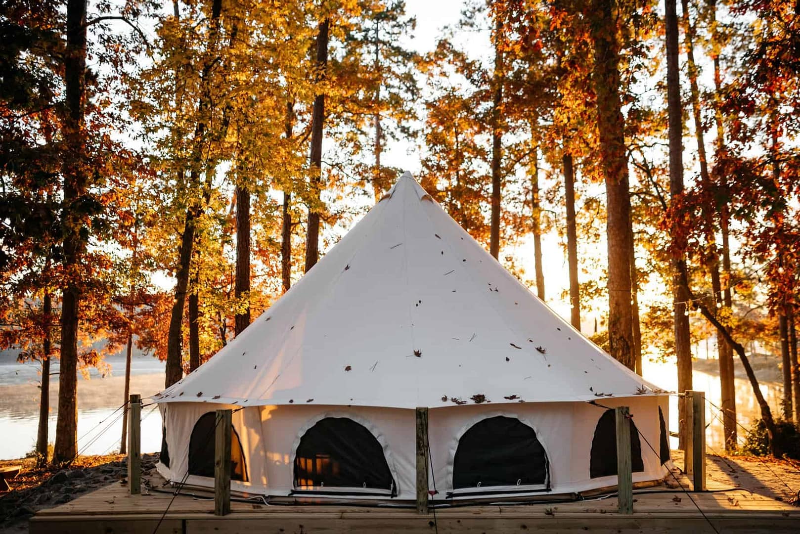 A luxurious white yurt sitting on a wooden deck in the Augusta woods, now under new ownership.