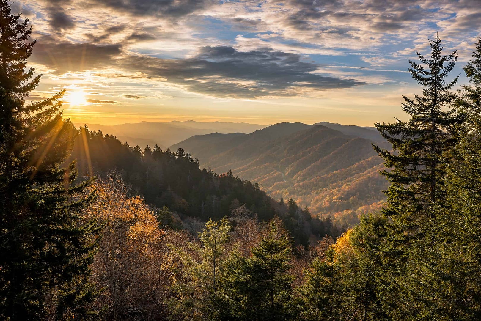 The sun rises over a forest in the mountains of the Cherokee National Forest.