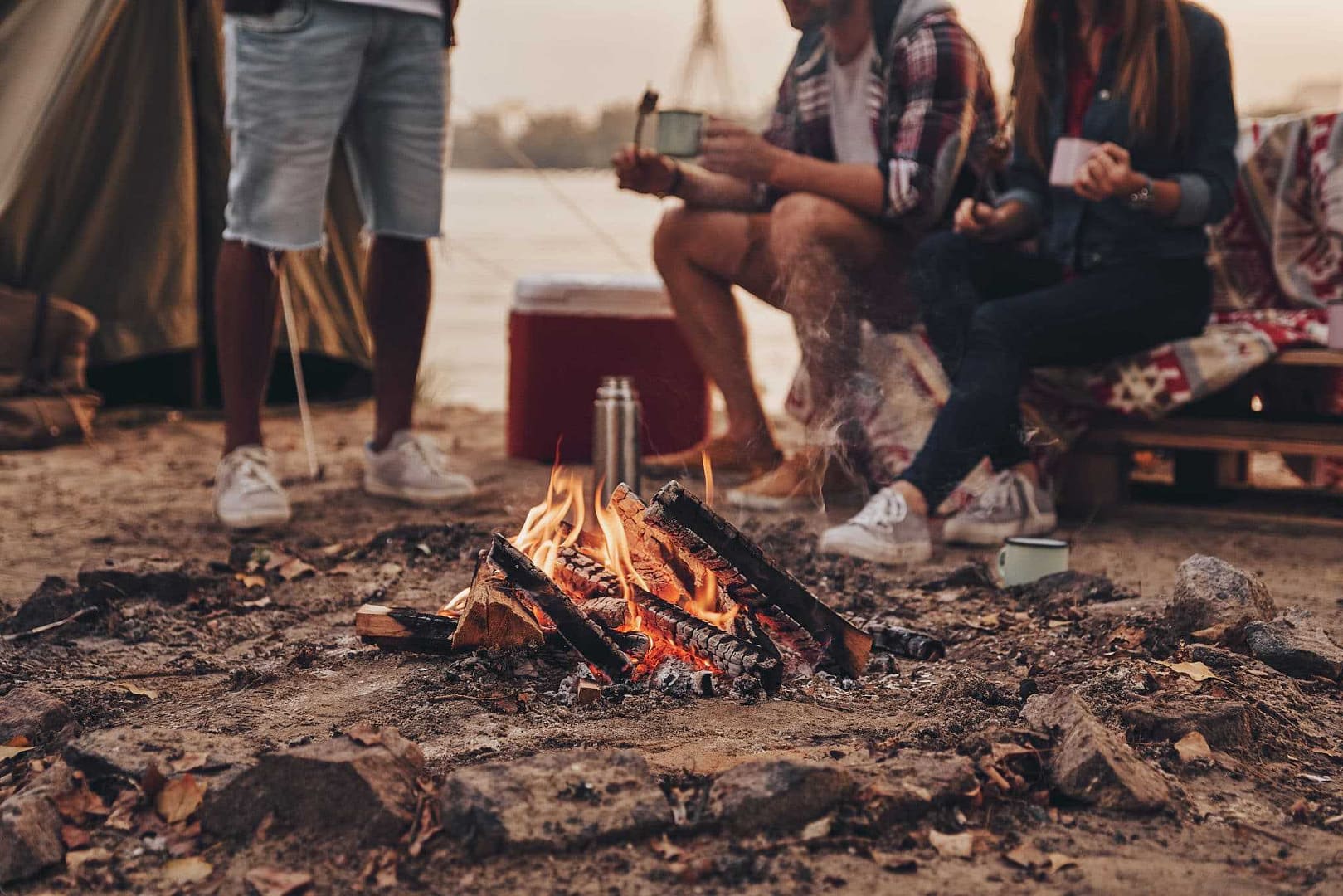 A group of people in the Queenstown Lakes District Council area, practicing freedom camping around a campfire.