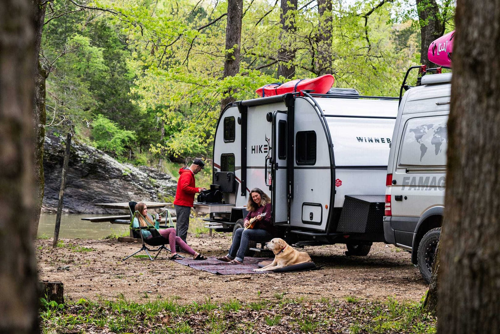 A group of people camping in an RV near a river at the Florida RV Show with their Winnebago Micro Minnie FLX.