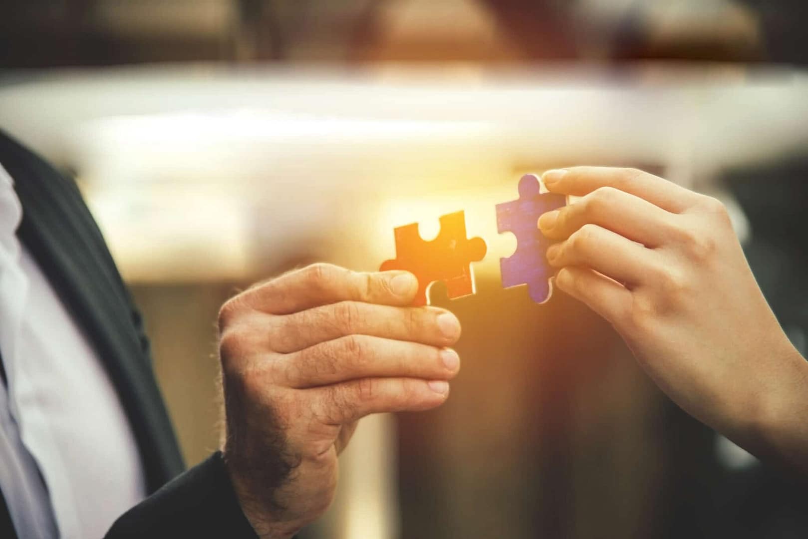 Two business people holding a piece of jigsaw puzzle in an Online Marketplace.