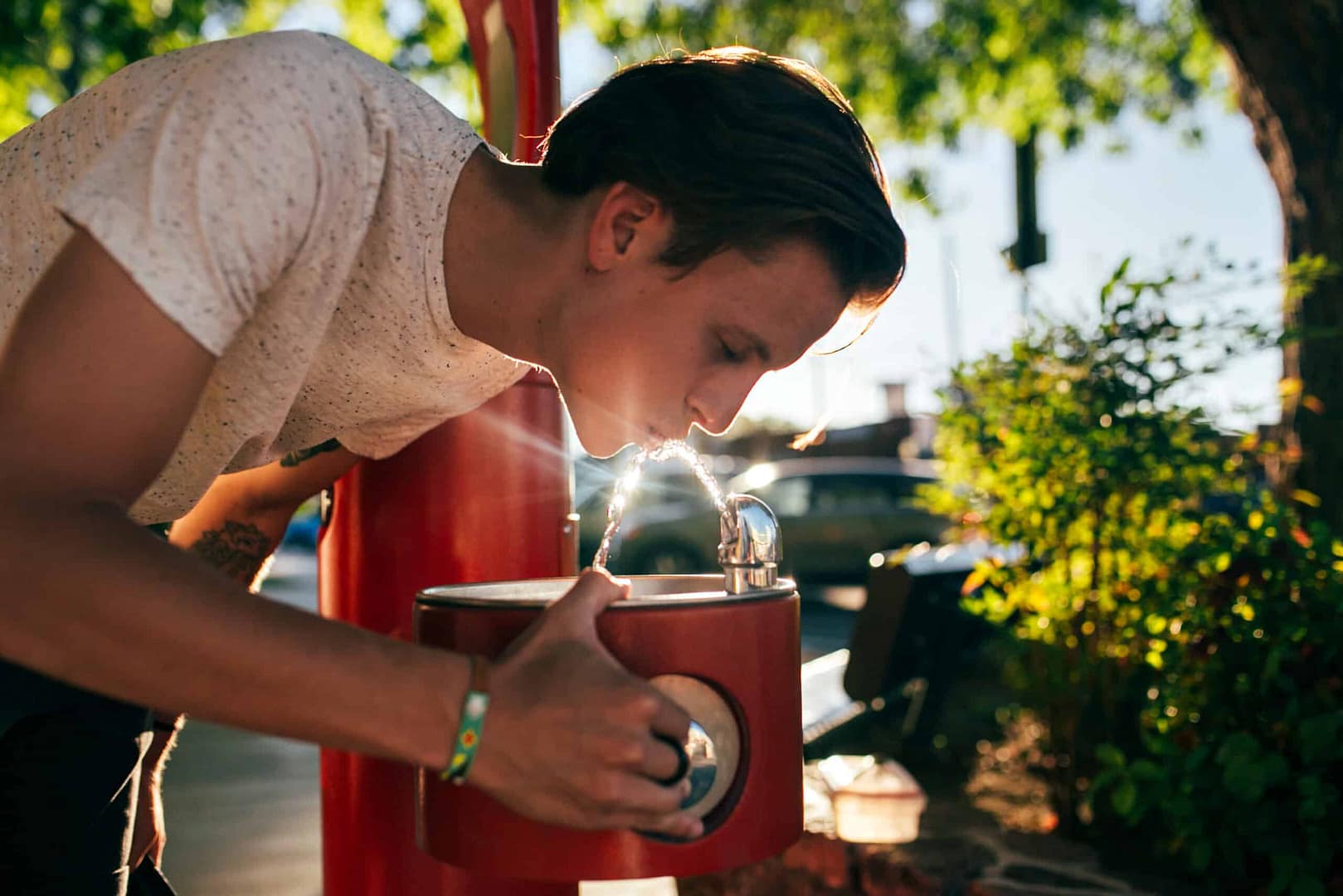 A young man drinking from a water fountain in one of NY State Parks.