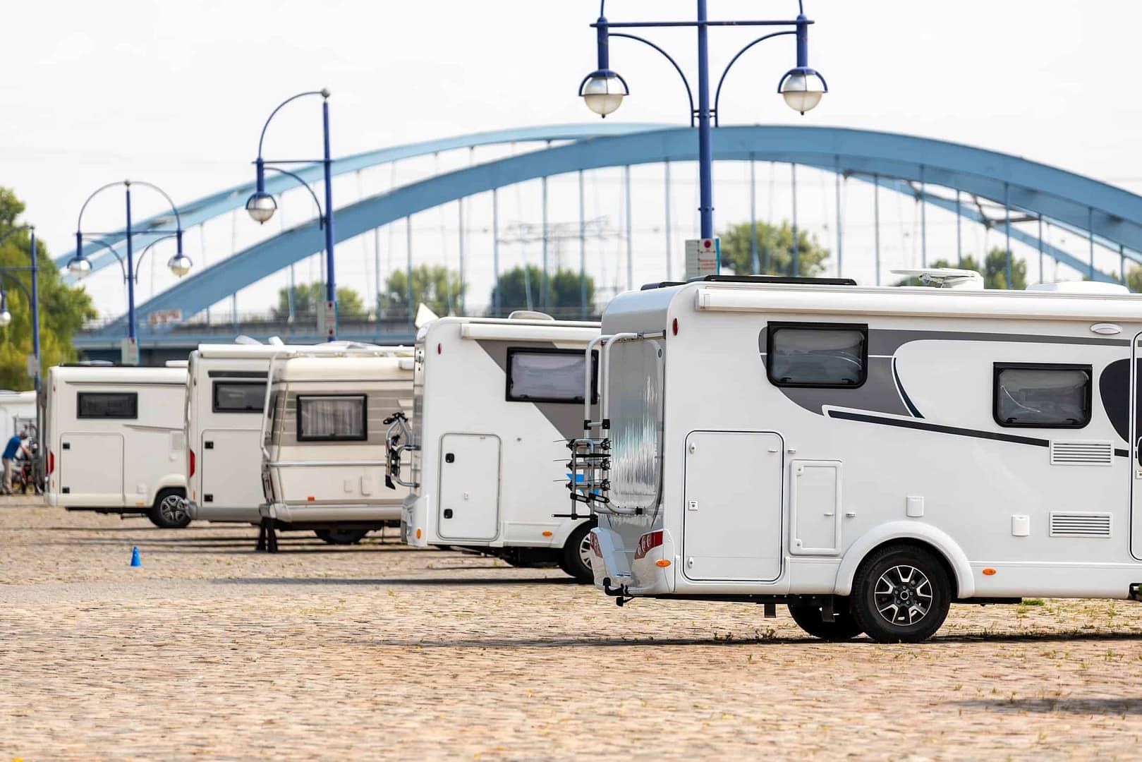 A group of German RVs parked in front of a bridge, showcasing the expansion and influence of the RV industry in Malaysia.