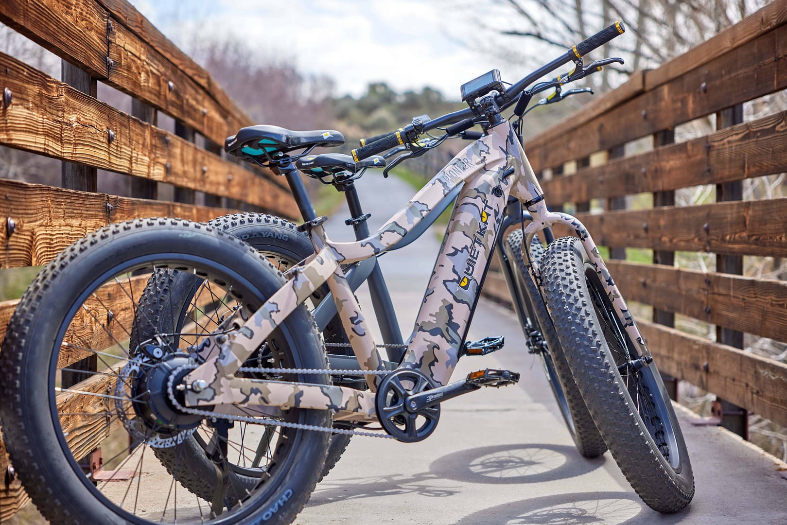 Two QuietKat fat bikes parked on a wooden bridge.