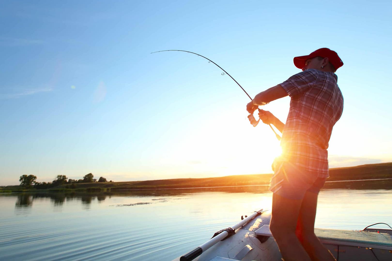 A man is fishing on a boat at W. Kerr Scott Reservoir during recreational season.