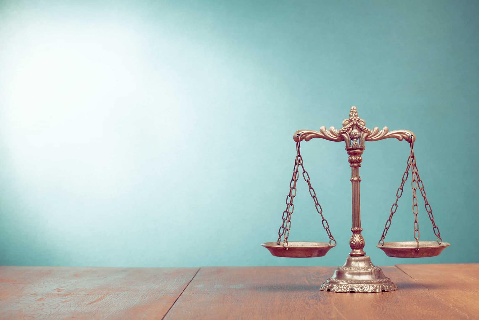 Former RV sales owners implicated in fraudulent activity face potential jail time and hefty fines, depicted by a scale of justice on a table with a blue background.