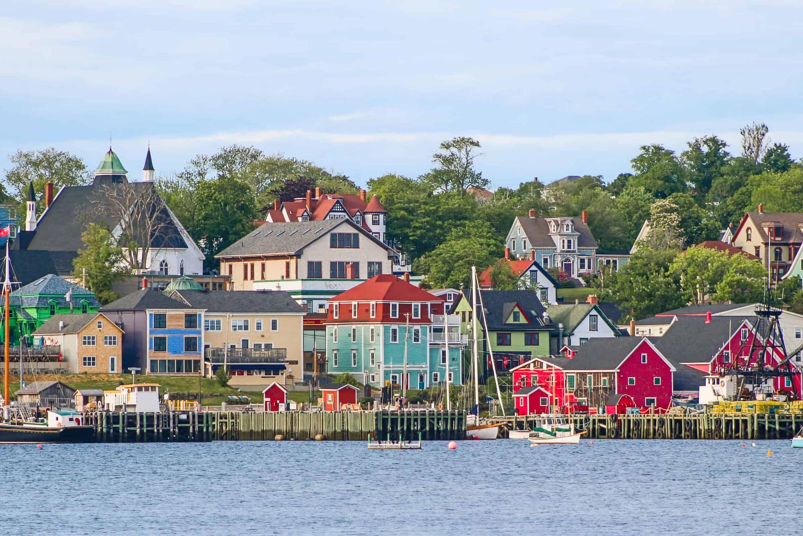 Colorful houses on the registered tourist accommodations of Nova Scotia, situated on the shore of a body of water.