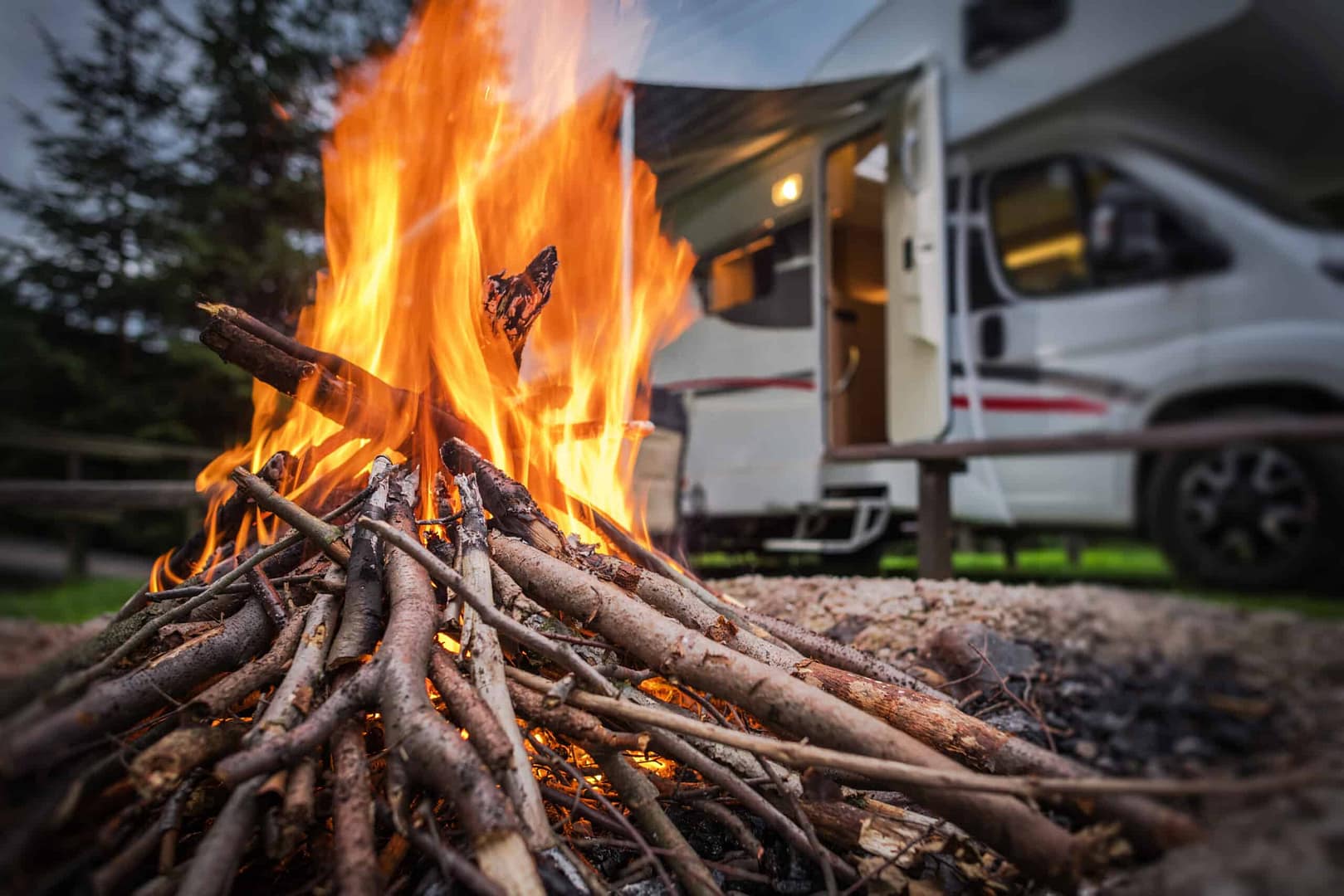 A campfire in front of an RV park.