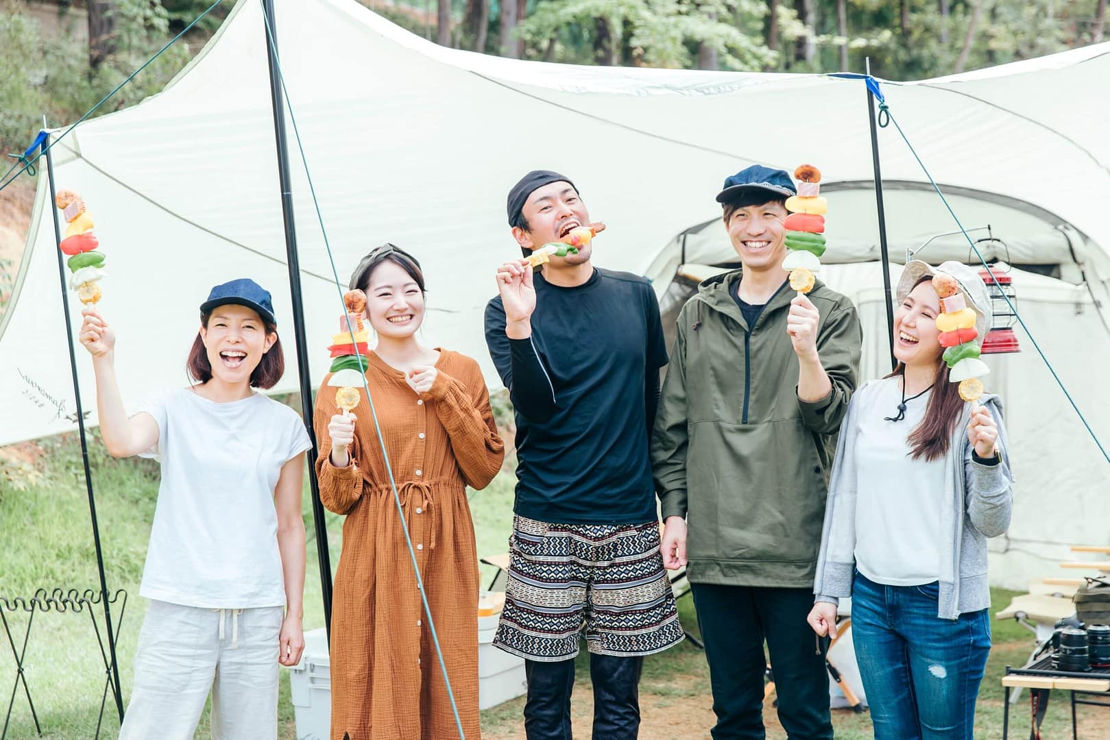 A group of people enjoying camping in front of a tent amidst the urban stress of China.