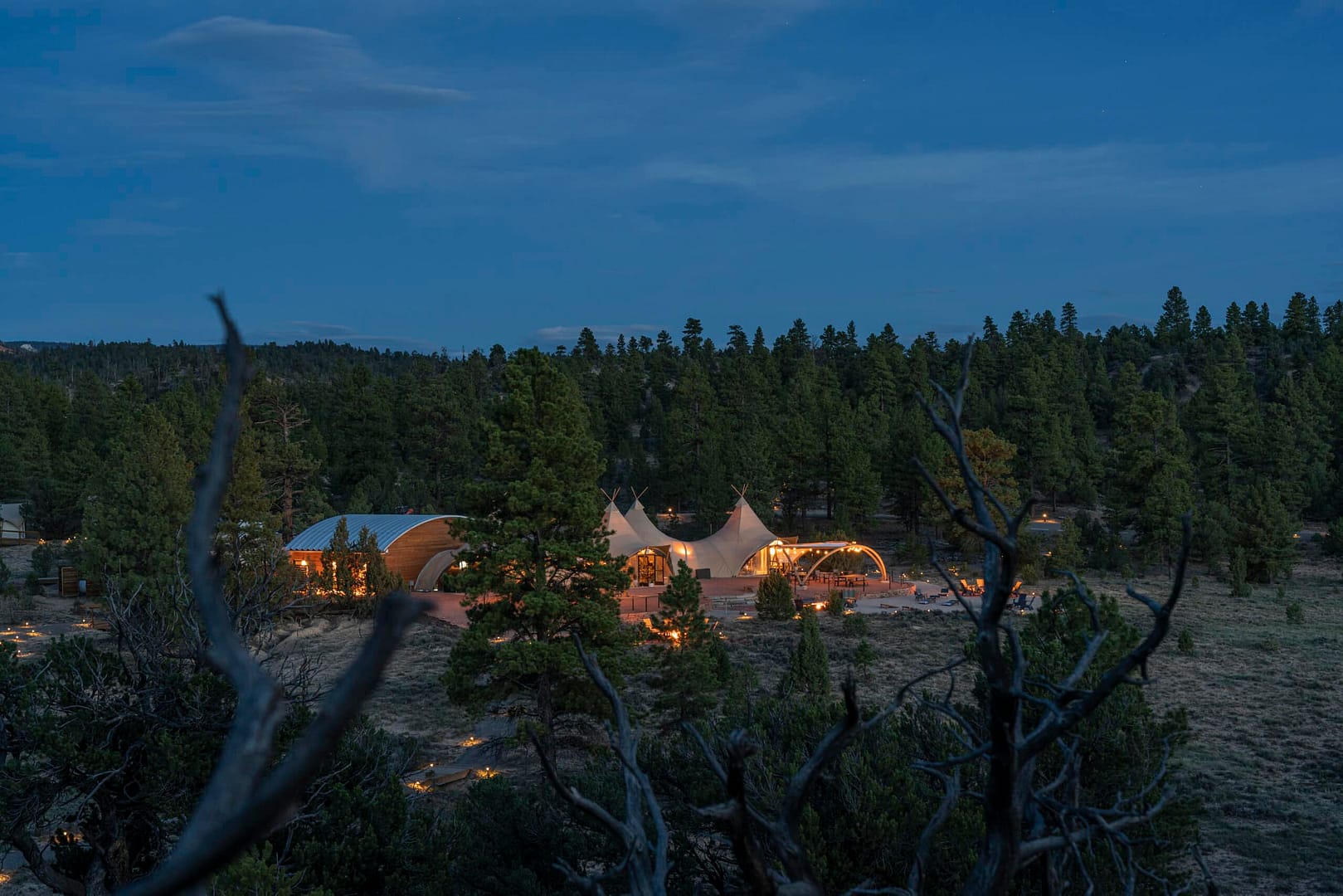 Under Canvas tepee tent in the middle of a forest at dusk during a Backroads adventure in U.S. National Parks.