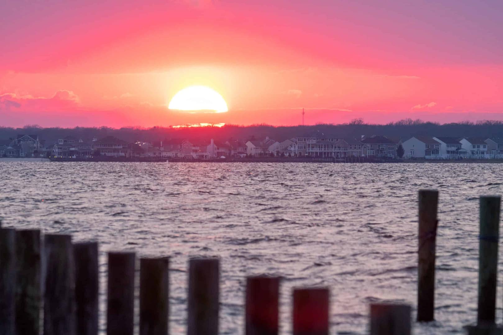 The sun is setting over a body of water at New Jersey State Parks.