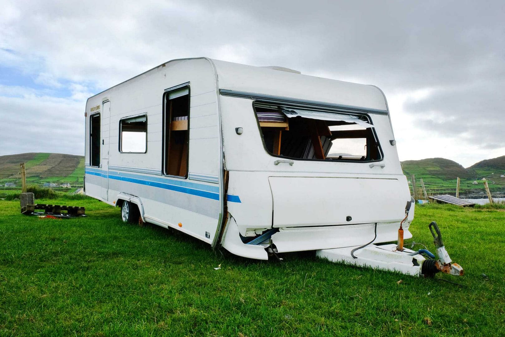 A white camper parked in a grassy field, designated for motorhome parking by the Northern Ireland District Council.