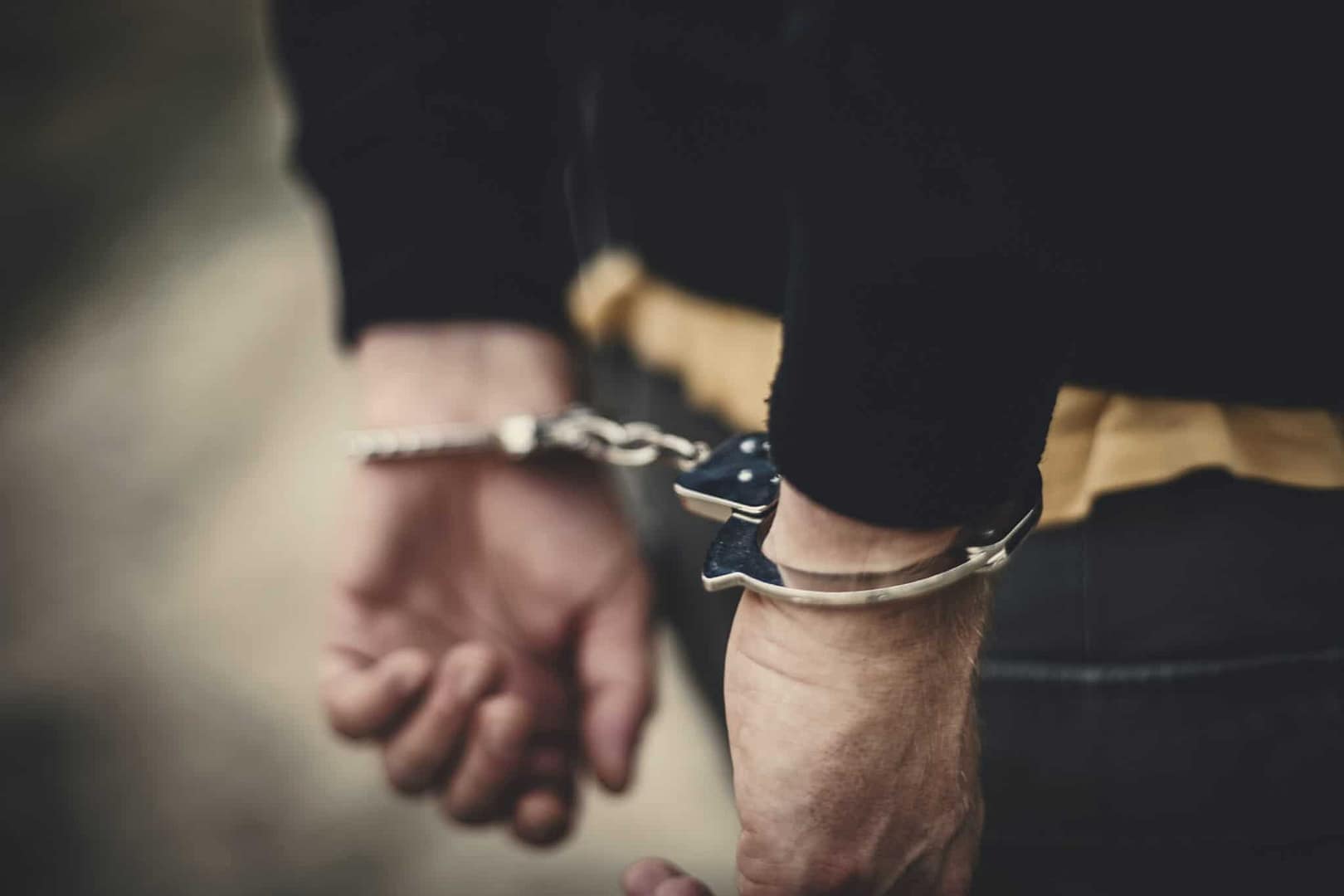 A man from Maine with handcuffs on his hands, on a camping trip.