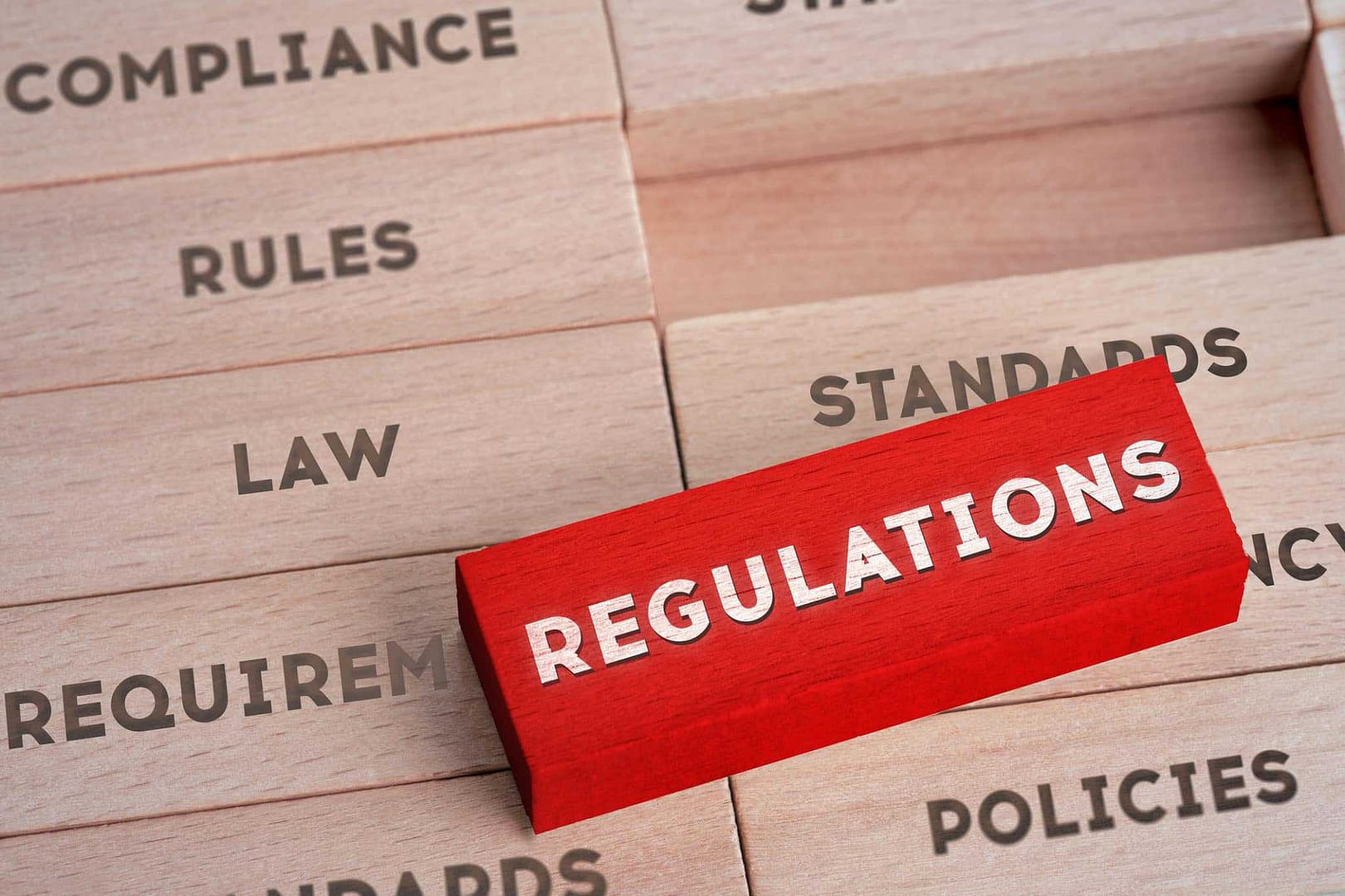 A red block with the word regulations stacked on top of it.
