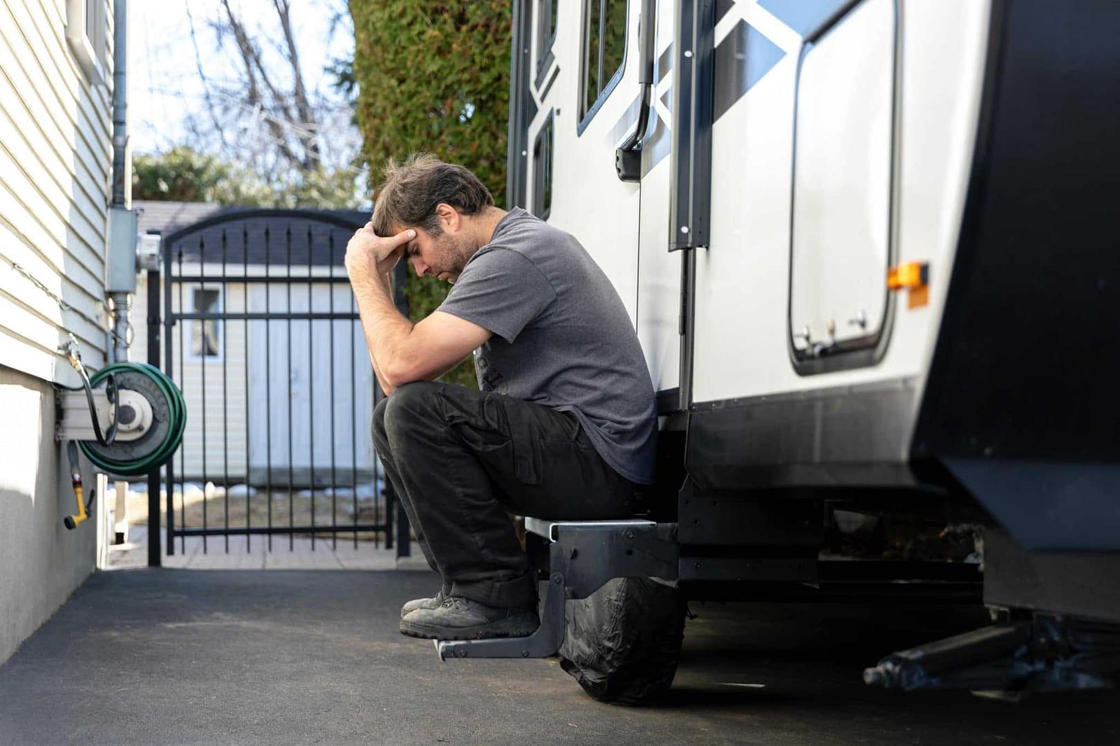 A blindsided man sitting on a trailer in an NZ park.