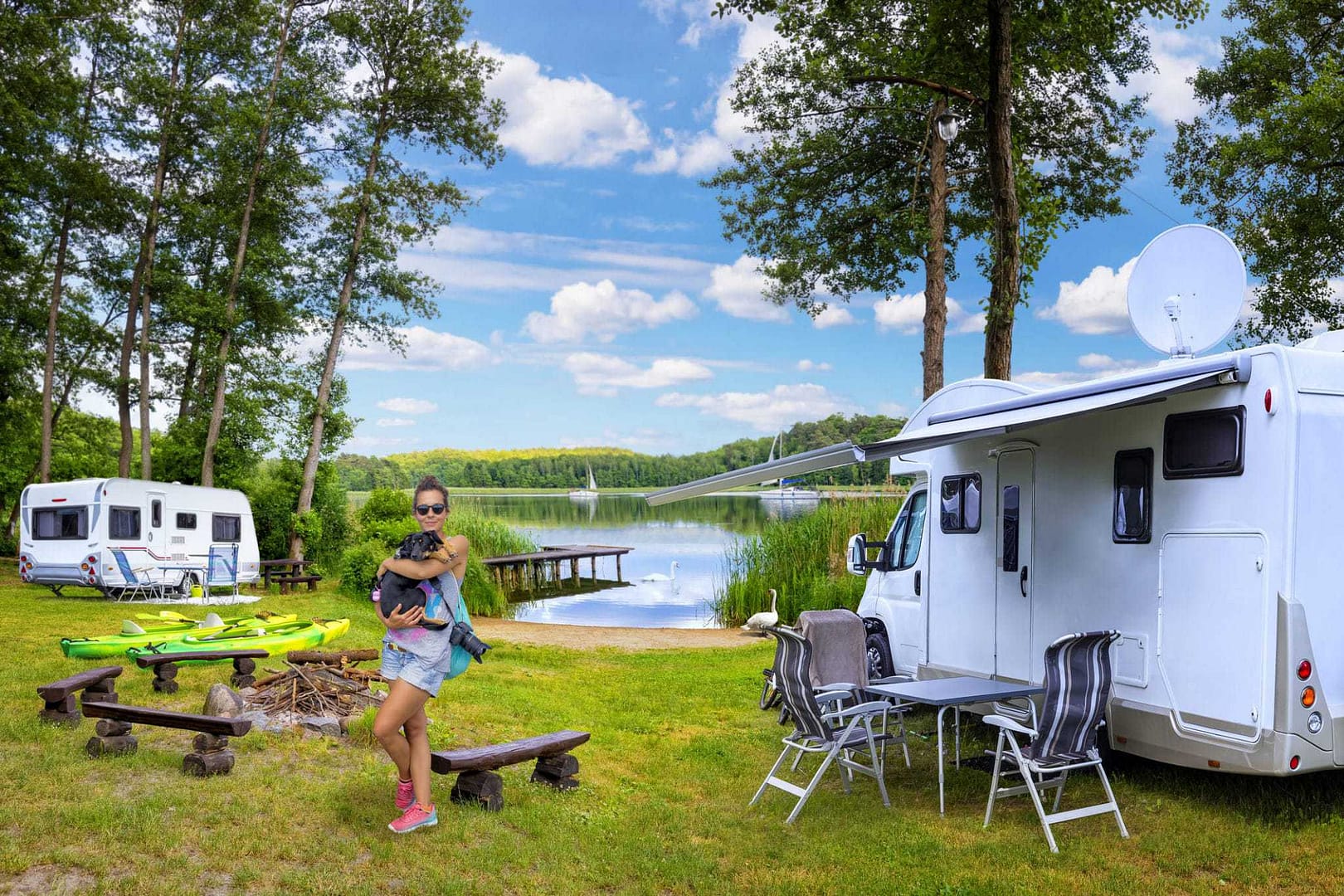 An rv park with a woman and a dog near a lake.