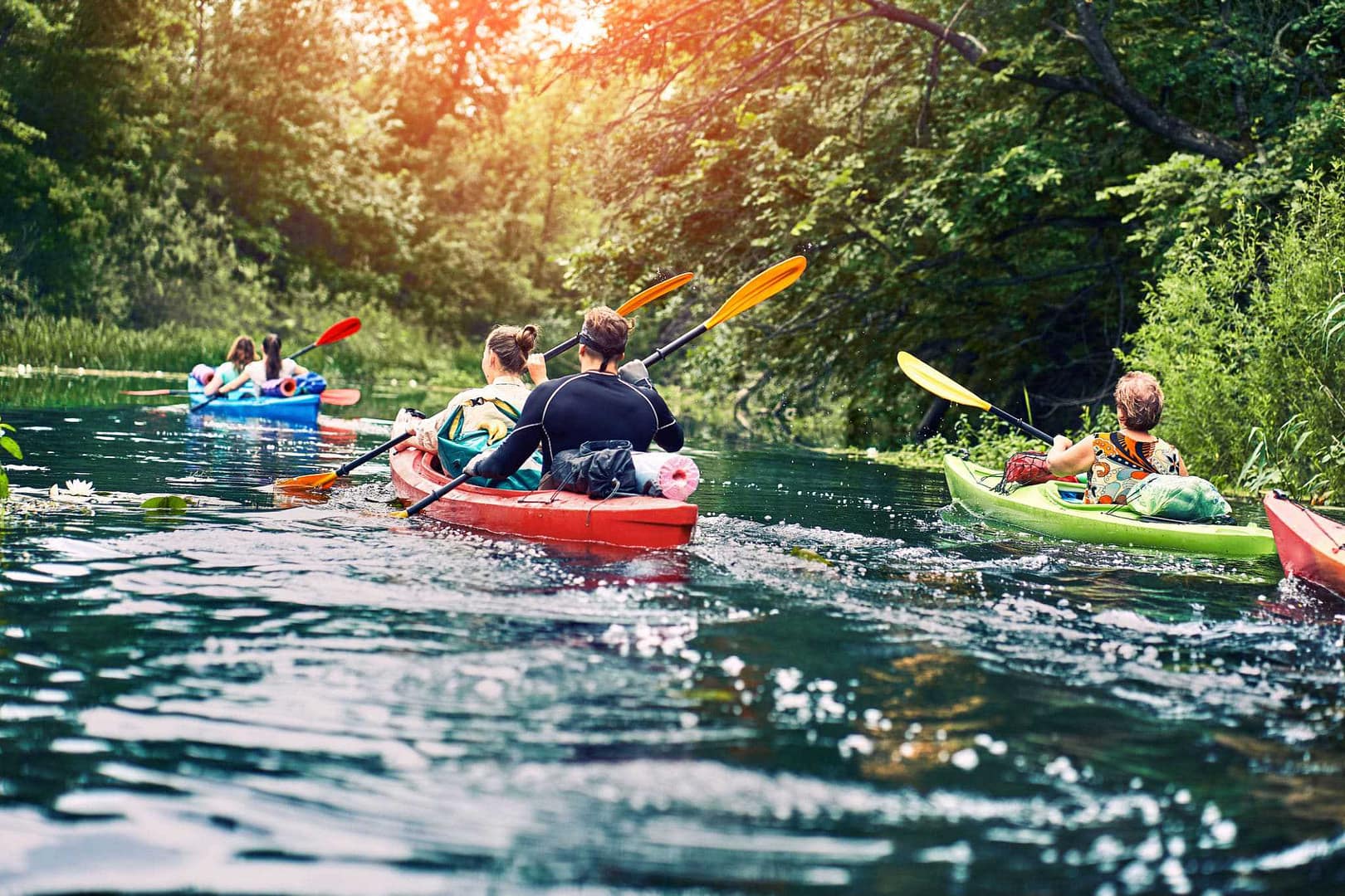 A group of boys kayaking down a river.