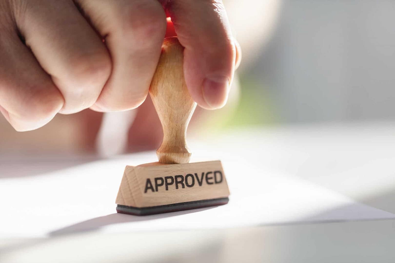 A person holding a rubber stamp with the word approved on it, engaged in zoning or planning activities in Arizona.