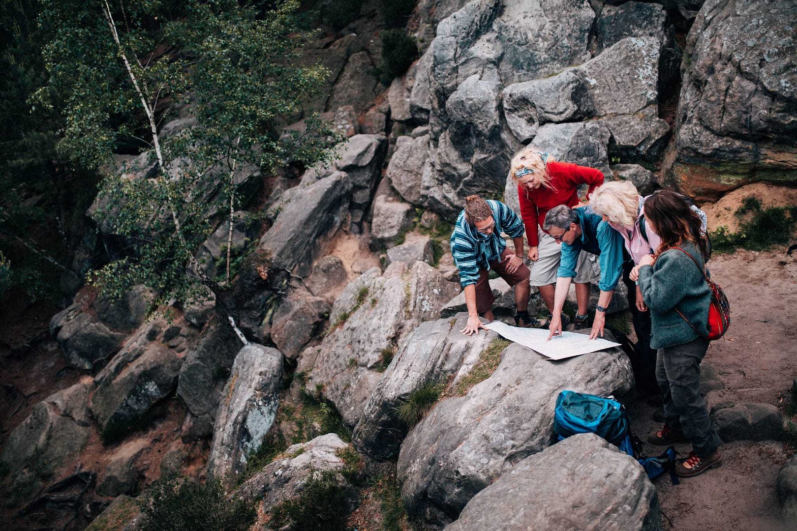Maine residents looking at a map on a rock.