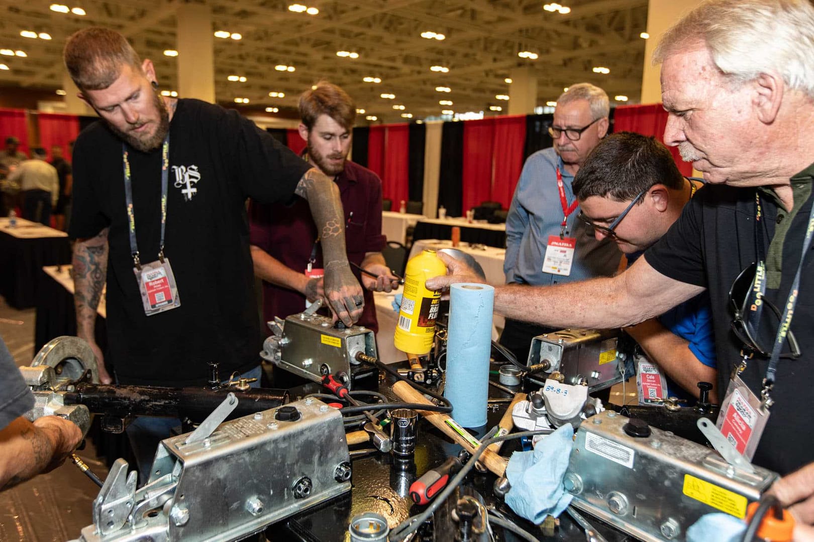 A group of men working on a machine at the NATDA Trailer Show in Nashville, 2021.