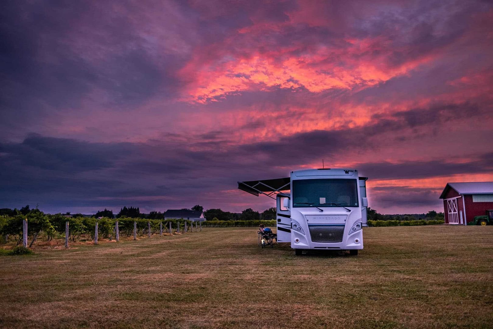 An RV parked in a field at sunset, providing a serene setting for agritourism enthusiasts and RVers.