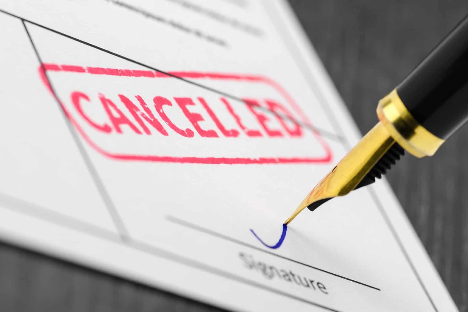 A pen is writing the word cancelled on a piece of paper due to Huge Losses caused by COVID-19 Misinformation.