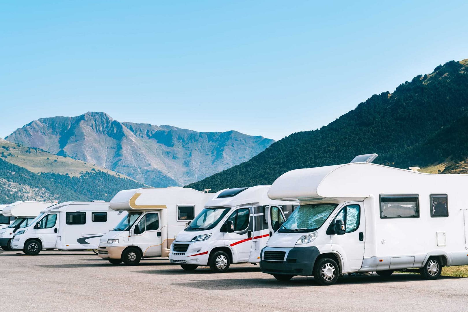 A caravan parked in front of mountains, offering a picturesque camping experience in the UK.
