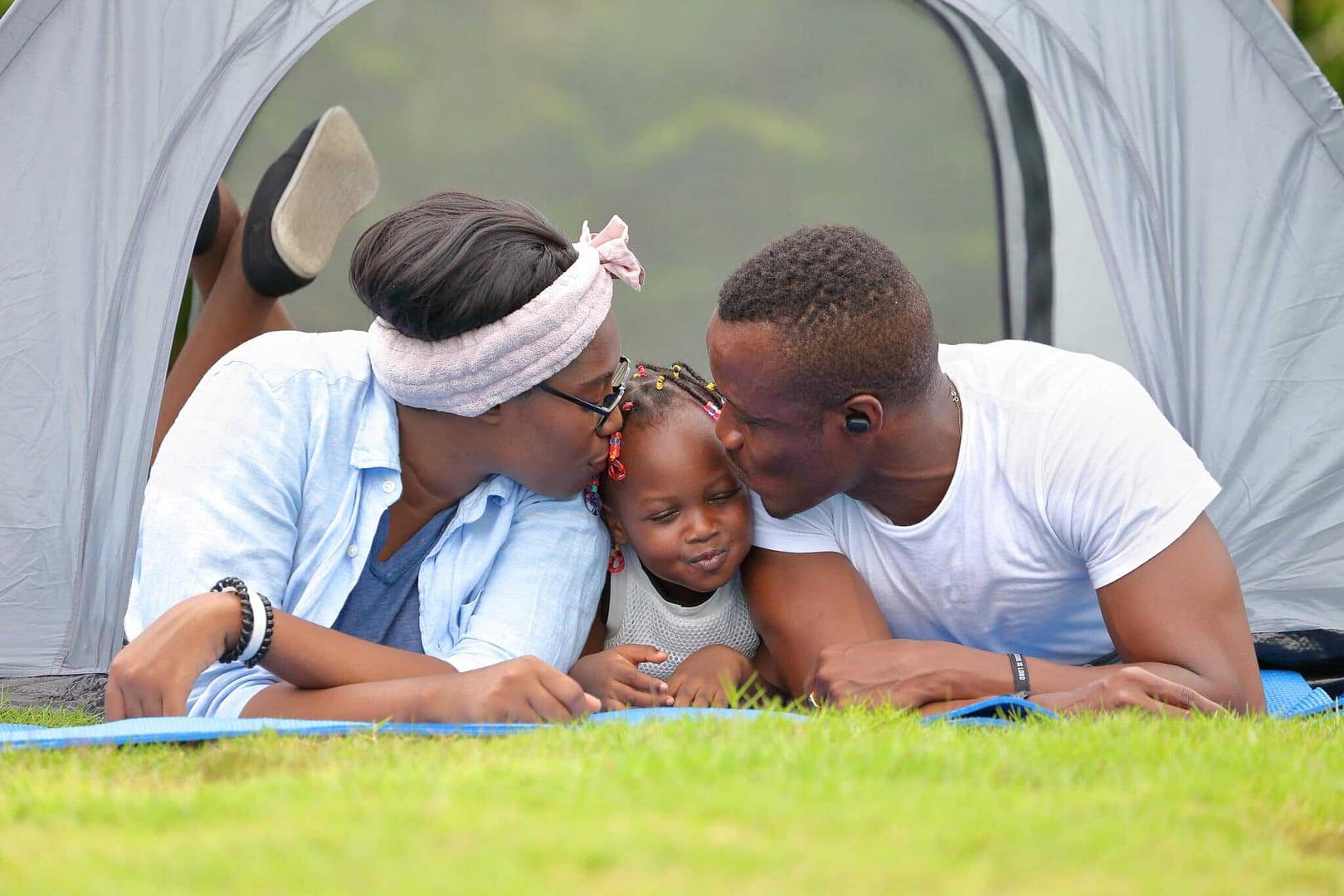 In celebration of Black History Month, a couple embraces in front of a tent amidst the beautiful Washington wilderness, as they enjoy a romantic moment during their Fish and Wildlife adventure.