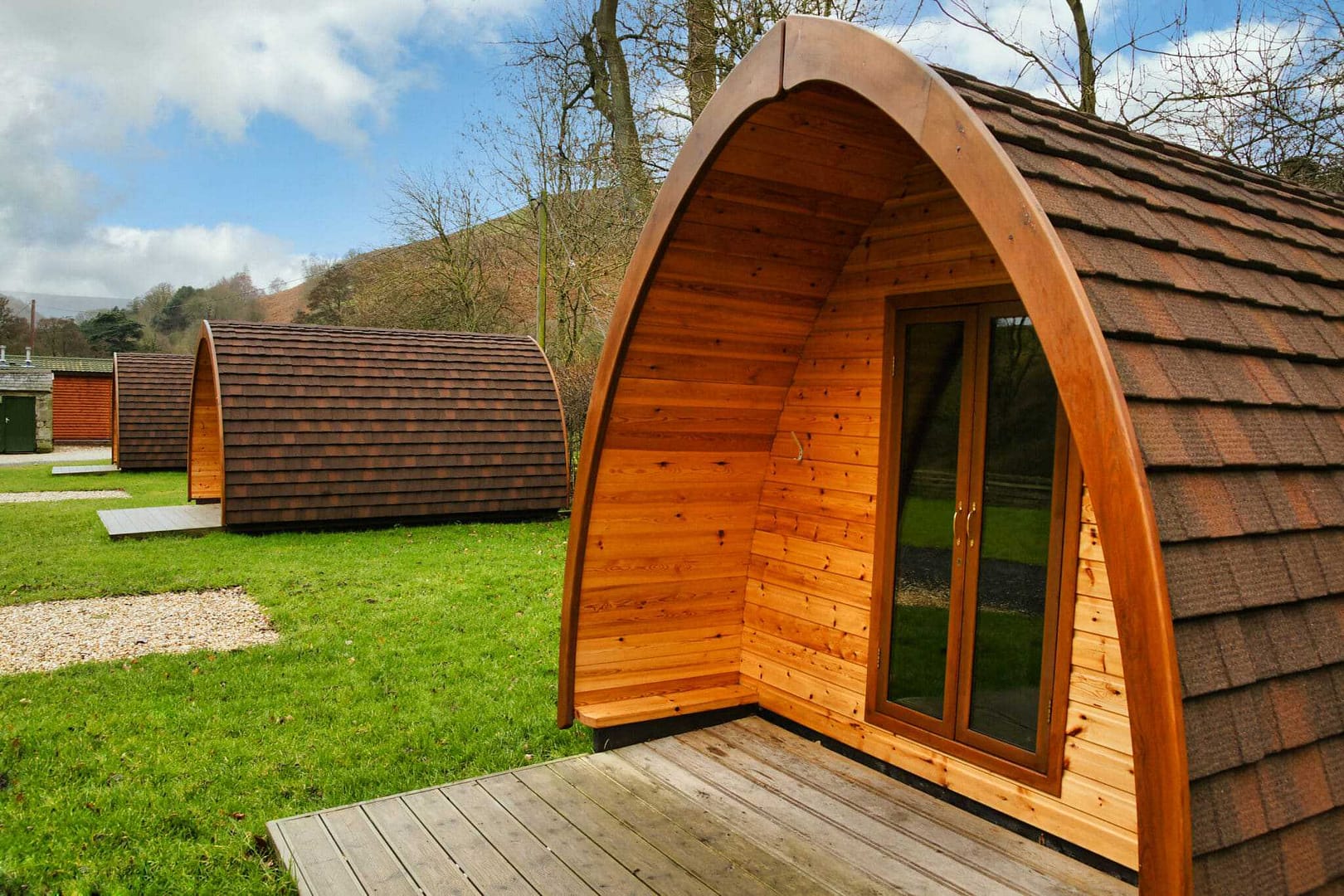A group of wooden cabins in a grassy area.