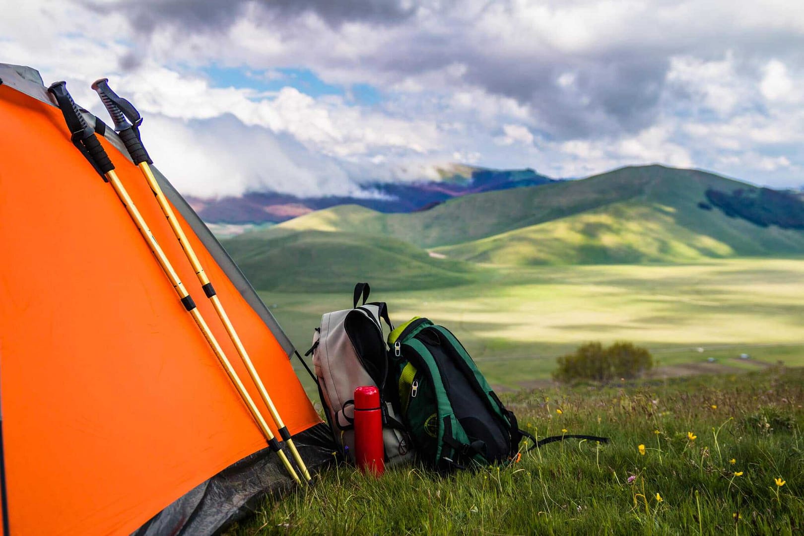 An outdoor recreation tent is set up in a grassy field, supported by a grant from Kootenay.