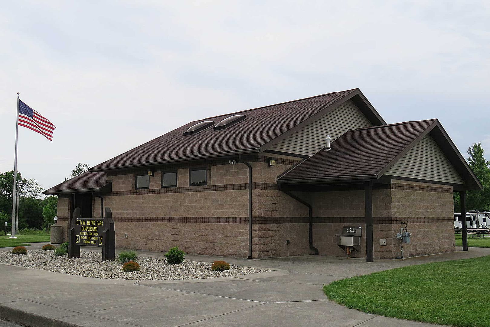 A brown building with an American flag located in the Johnny Appleseed Metropolitan Park District.
